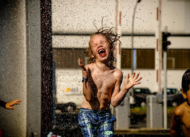 Ragazzo senza camicia che gioca con l'acqua