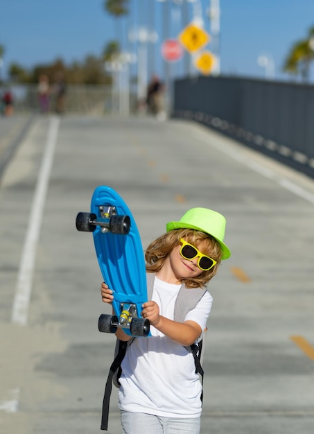 Ragazzo skateboarder nel skate park ragazzino con skateboard concezione di stile di vita di svago per l'infanzia