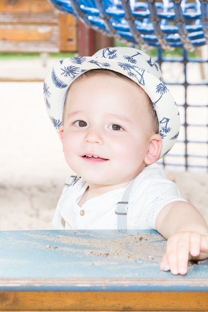 Ragazzo smilong playong su hute di legno al parco giochi