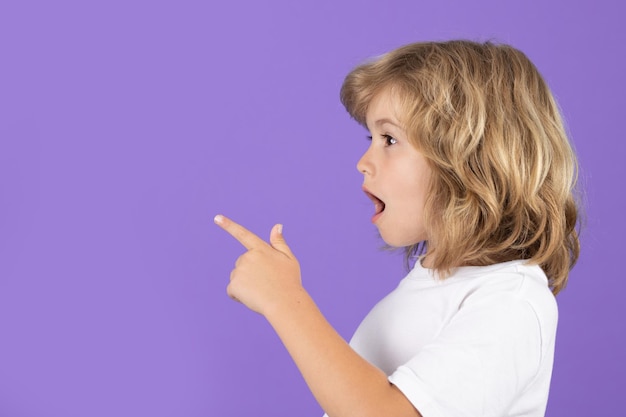 Ragazzo sorpreso che guarda da un'altra parte e indica con il dito uno studio isolato sullo sfondo. Ragazzo scioccato che indica un poliziotto.