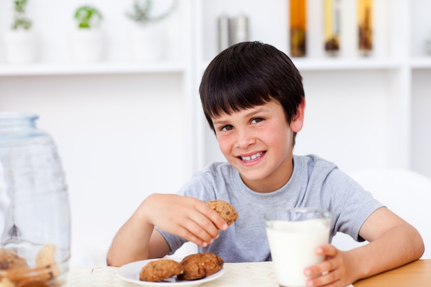 Ragazzo sorridente che mangia i biscotti