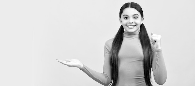 Ragazzo sorridente che presenta lo spazio della copia del prodotto pubblicità piuttosto teenager della ragazza su sfondo giallo Bambino faccia poster orizzontale ragazza adolescente isolato banner ritratto con spazio di copia