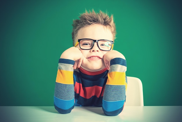 Ragazzo sorridente con gli occhiali Sfondo verde Primo piano