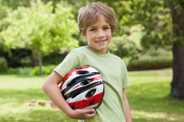 Ragazzo sorridente con il casco della bicicletta al parco