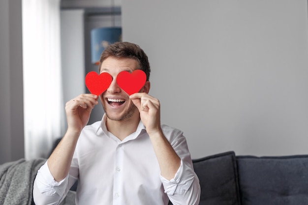 Ragazzo sorridente con il cuore vicino agli occhi