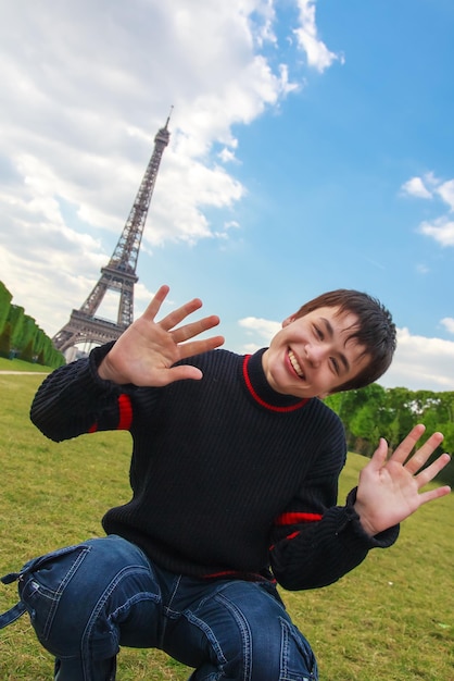 Ragazzo sorridente davanti alla Torre Eiffel La Tour Eiffel in Par