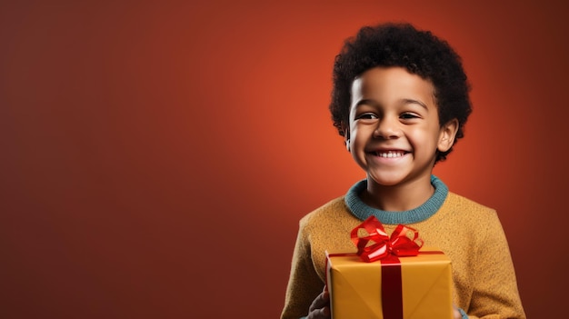 Ragazzo sorridente felice che tiene il contenitore di regalo su uno sfondo colorato