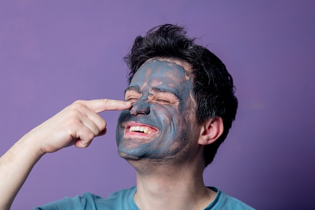 Ragazzo sorridente in una maschera per la cura del viso