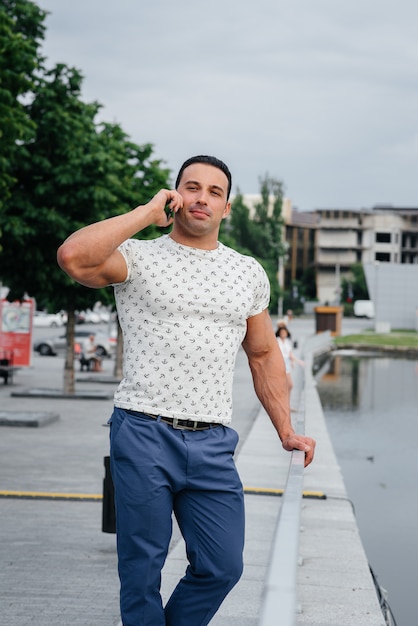 Ragazzo sportivo si alza e parla al telefono. Stile di vita.