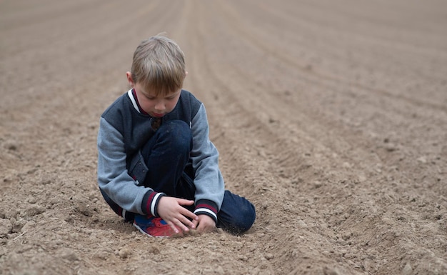 Ragazzo su un campo arato in primavera