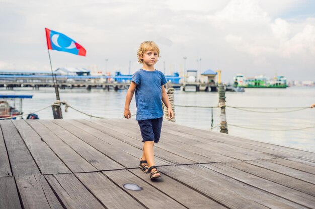 Ragazzo sul ponte di legno del clan tan jetty nella città di George Penang