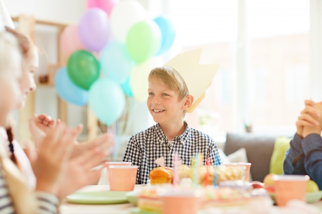 Ragazzo sveglio che sorride alla festa di compleanno