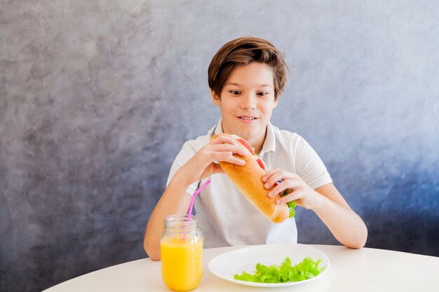 Ragazzo teenager sveglio che mangia prima colazione sana a casa