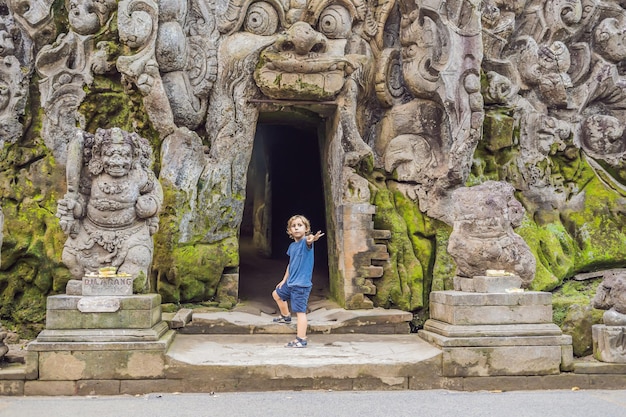 Ragazzo turistico nel vecchio tempio indù di Goa Gajah vicino a Ubud sull'isola di Bali, Indonesia. Viaggia a Bali con il concetto di bambini.