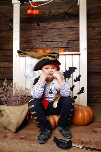 Ragazzo vestito da pirata sullo sfondo di decorazioni di Halloween