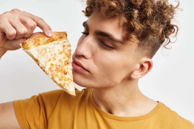 Ragazzo vizioso che mangia pizza in posa primo piano sfondo isolato