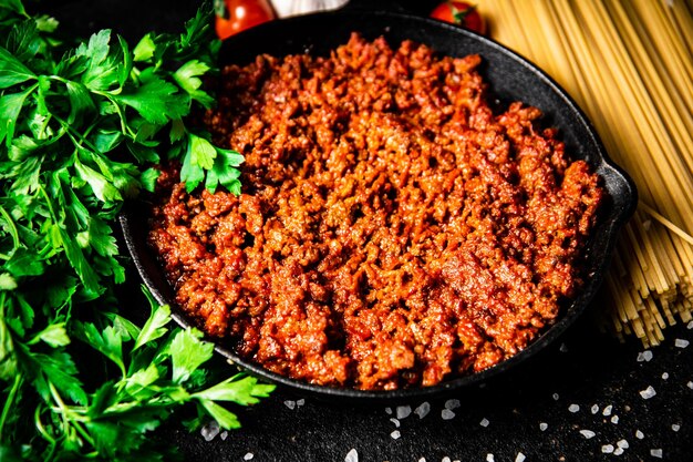 Ragù alla bolognese in padella con pasta secca e prezzemolo