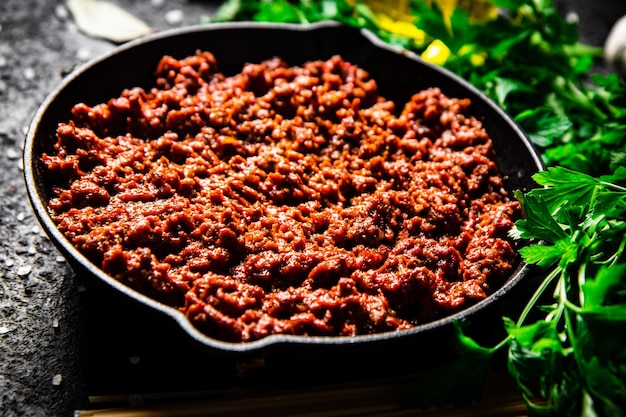 Ragù alla bolognese in padella con pasta secca e prezzemolo