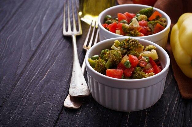 Ragù di verdure con pomodoro, broccoli, piselli, pepe. Messa a fuoco selettiva