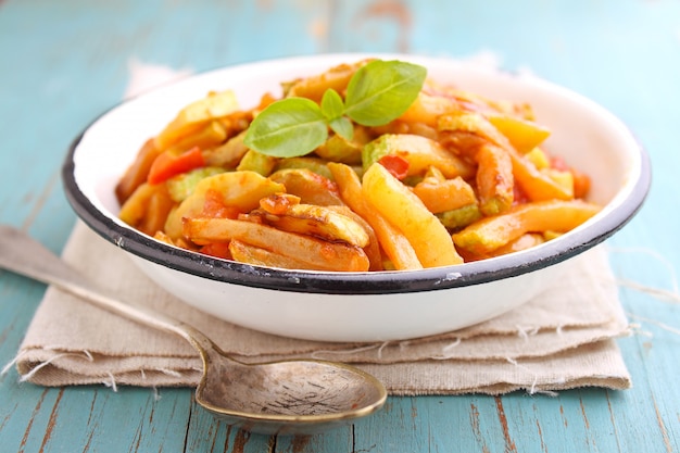 Ragù di zucchine e pomodoro con aglio e basilico, in un piatto bianco, messa a fuoco selettiva