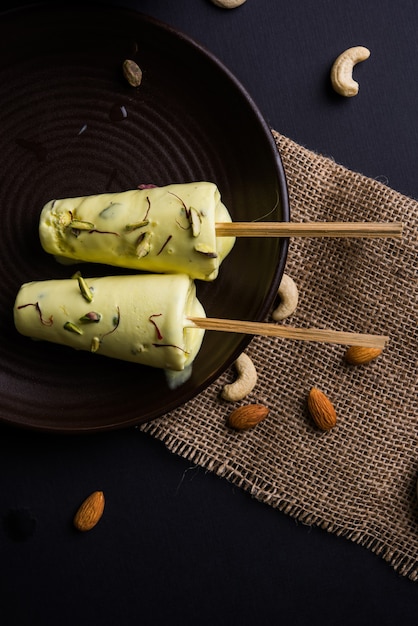 Rajasthani fatto in casa pronto da mangiare matka kulfi - zafferano o kesariya aromatizzato con pistacchio, anacardi e mandorle, messa a fuoco selettiva