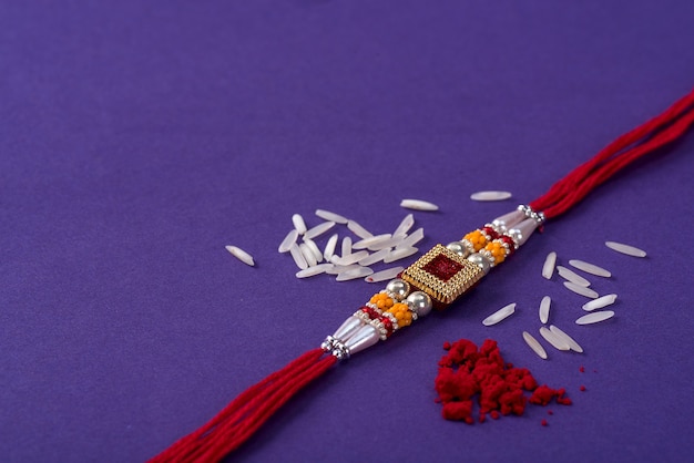 Rakhi con chicchi di riso e kumkum. Uno sfondo festivo indiano