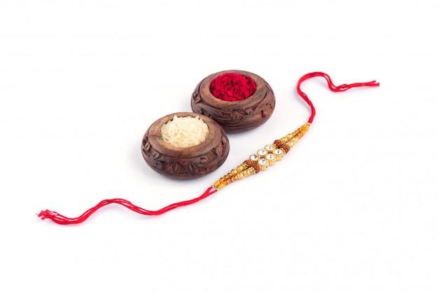 Raksha Bandhan con un elegante Rakhi, chicchi di riso e Kumkum. Un tradizionale cinturino da polso indiano che è un simbolo di amore tra fratelli e sorelle.