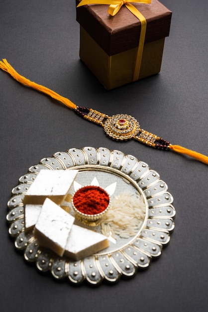 raksha bandhan saluto rakhi e regalo con dolce kaju katli o mithai e chicchi di riso kumkum