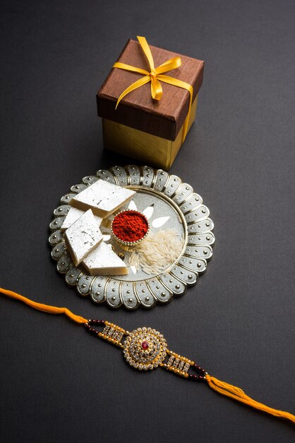 raksha bandhan saluto rakhi e regalo con dolce kaju katli o mithai e chicchi di riso kumkum