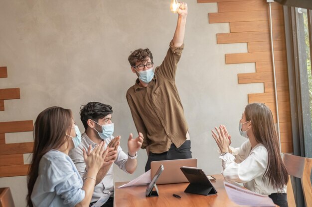 Rallegrati, gruppo di uomini d'affari stupiti, lavoro di squadra di giovani asiatici, caucasici che si divertono, felici sul posto di lavoro dopo che il progetto è terminato, vinci durante la conferenza con i partner sul laptop. Celebrare il concetto di successo.