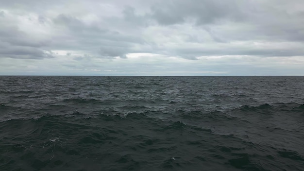 Rallentatore della superficie dell'acqua di mare disturbata con cielo drammatico