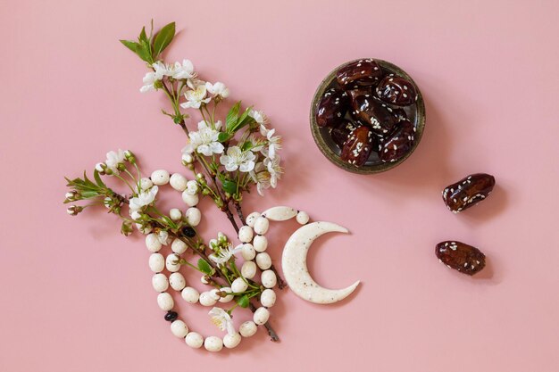 Ramadan cibo e bevande concetto Ramadan rosario islamico perline fiori bianchi e datteri frutta