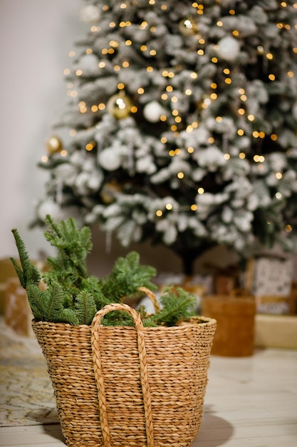 Rametti di un albero di Natale in un cesto di vimini sullo sfondo