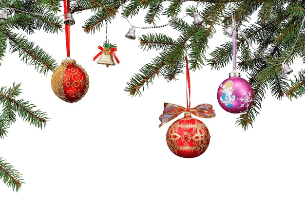 Rami di abete con palline, campane e altri ornamenti natalizi su sfondo bianco isolato