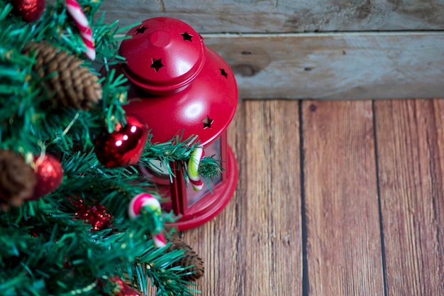 Rami di abete, decorazioni natalizie e lanterna rossa. fondo in legno