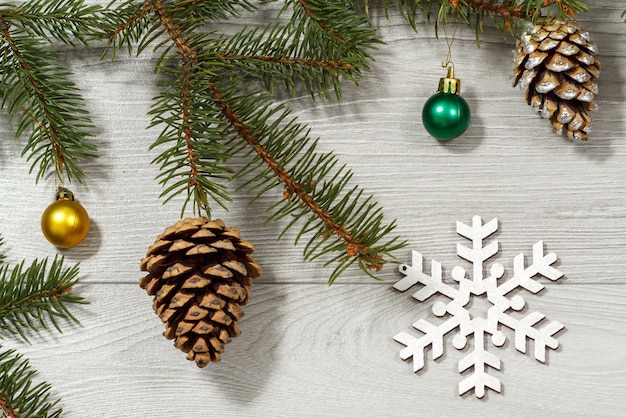 Rami di abete naturale con ornamento di Natale su sfondo di legno grigio