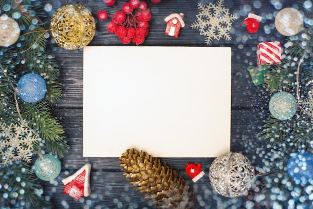 Rami di albero di Natale con bacche rosse e cornice di carta di carta nota e fiocchi di neve volanti Copiare lo spazio per il testo Concetto di natura nuovo anno Disposizione piatta