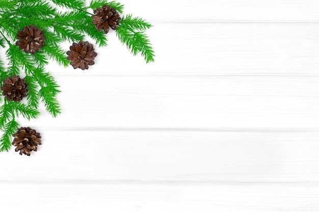 Rami di albero di Natale con pigne su tavola di legno bianco. Copia spazio. Sfondo di Natale