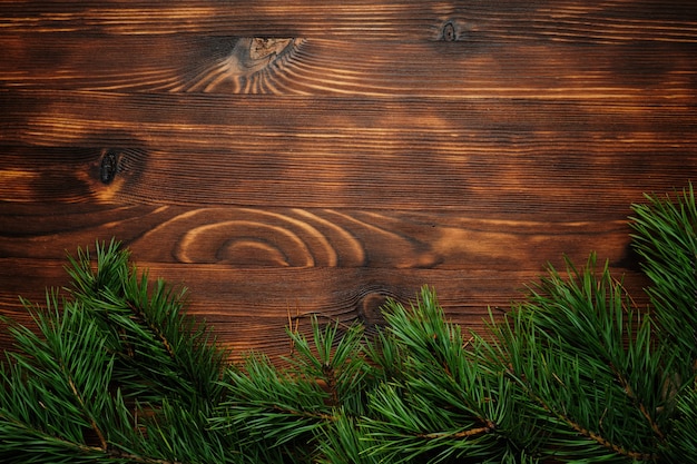 Rami di albero di Natale su uno sfondo di legno