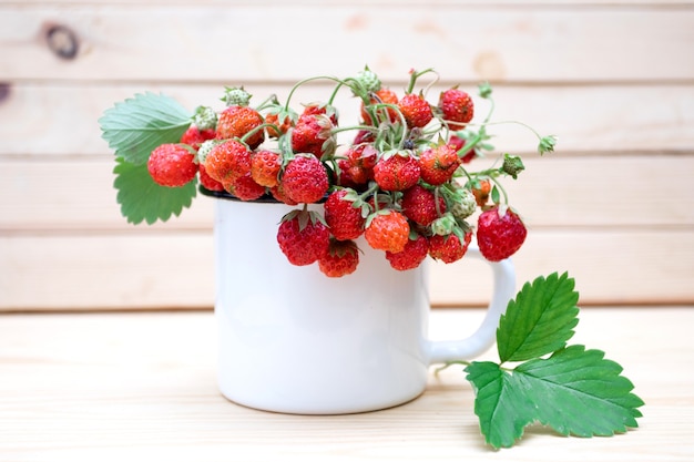 Rami di fragola matura fresca in una tazza bianca