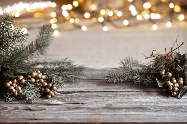 Rami di Natale di un albero di Natale su una tavola di legno e luci sfocate del bokeh.