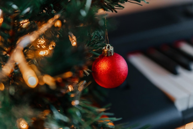 Rami di un albero di Natale decorato sullo sfondo dei tasti del pianoforte