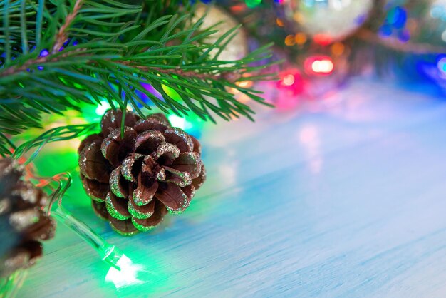 Ramo di abete con coni e luci di ghirlanda luminosa, decorazioni per la casa di capodanno