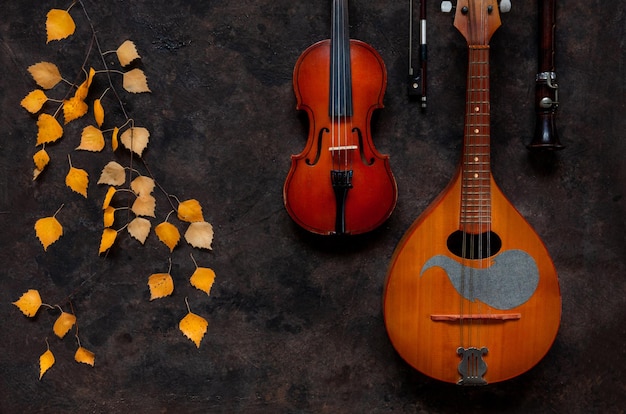 Ramo di betulla con foglie autunnali gialle mandolino violino e flauto Il concetto di eventi musicali e artistici autunnali