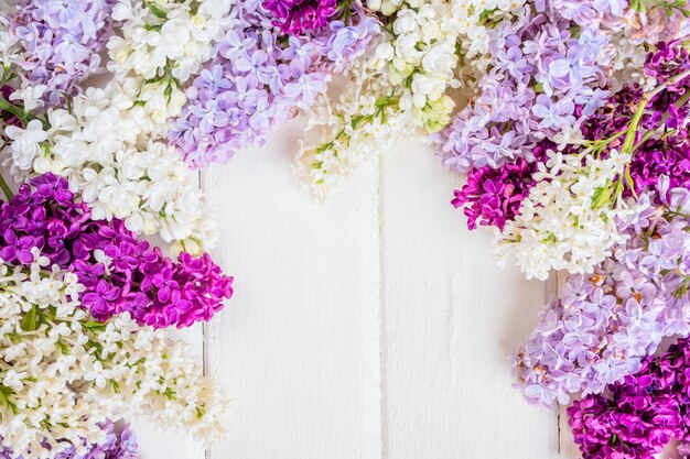 Ramo di fiori lilla su fondo di legno bianco con copyspace. Concetto di giorno di primavera o madre