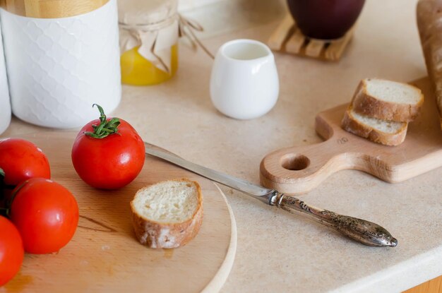 Ramo di pomodori freschi maturi e pomodori a fette su tagliere di legno Ingrediente per cucinare