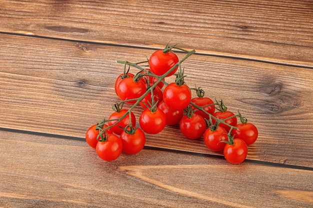 Ramo di pomodoro ciliegino dolce maturo su sfondo