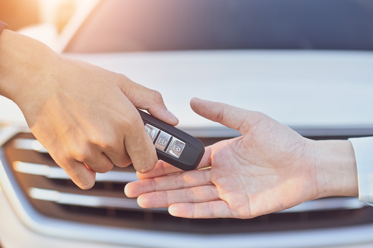 Foto rappresentante che fornisce automobile chiave al cliente, concetto di vendita dell'automobile
