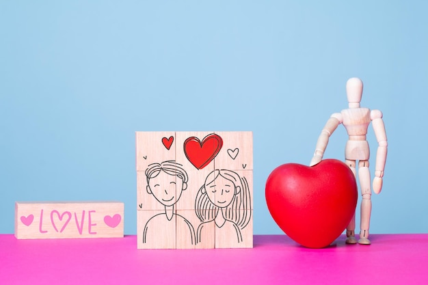 Rappresentazione dell'amore a San Valentino con cuore in legno rosso e disegni di coppie innamorate