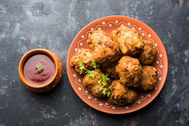 Rava Bhajj o bhajiya noto anche come suji Pakoda o semolina Pakora, servito con ketchup. messa a fuoco selettiva